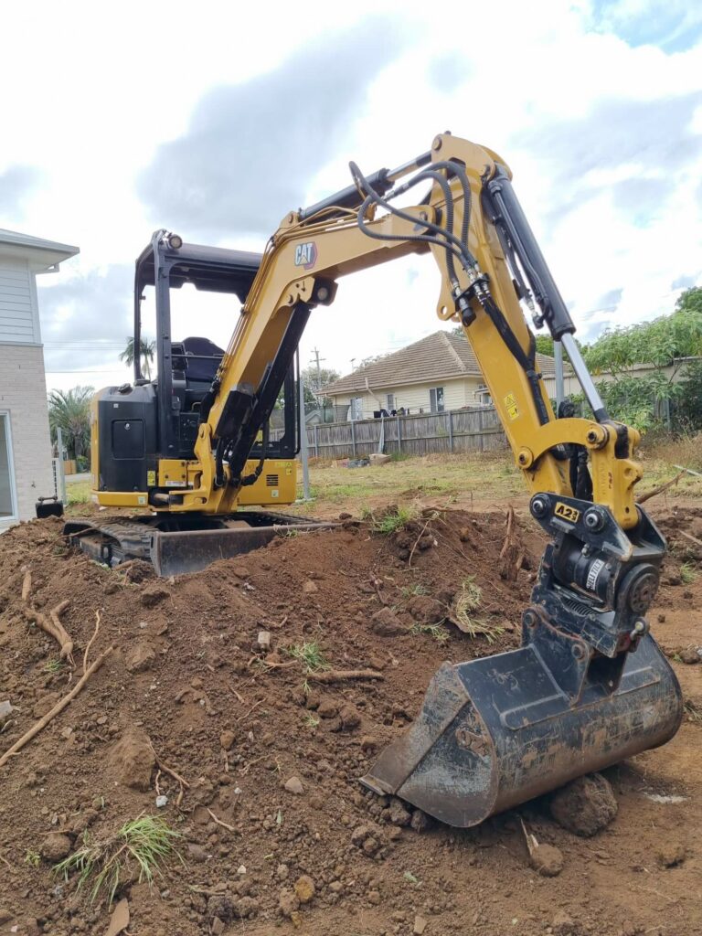 a CAT digger on a mound of dirt