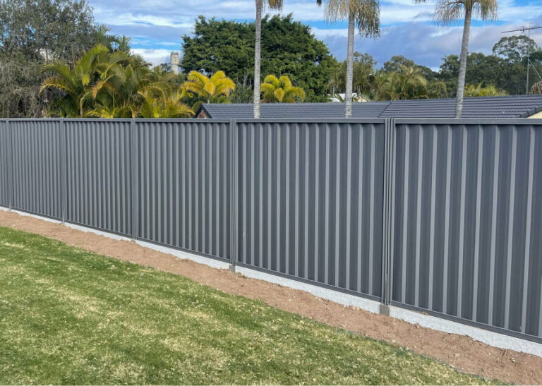 Grey colorbond fence with timber sleepers